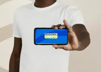 Pessoa segurando celular com aplicativo do CadÚnico para consultar microcrédito para empreender