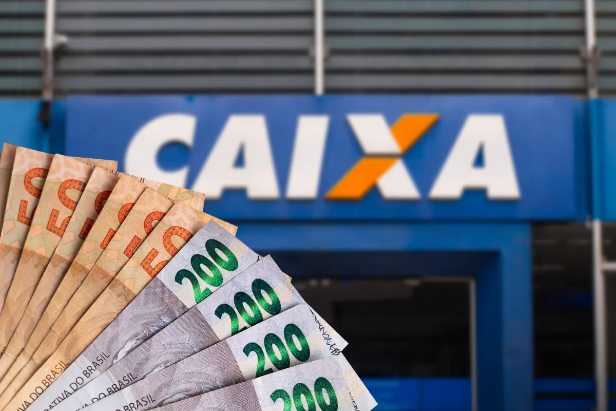 Saque calamidade de até R$ 6.220 pode ser solicitado pelo app FGTS; valor é depositado em conta da Caixa ou de outro banco. Notas de R$ 50 e R$ 200 em leque diante de fachada da Caixa Econômica Federal; banco libera saque de até R$ 6.220 do FGTS para mineiros afetados por enchentes.