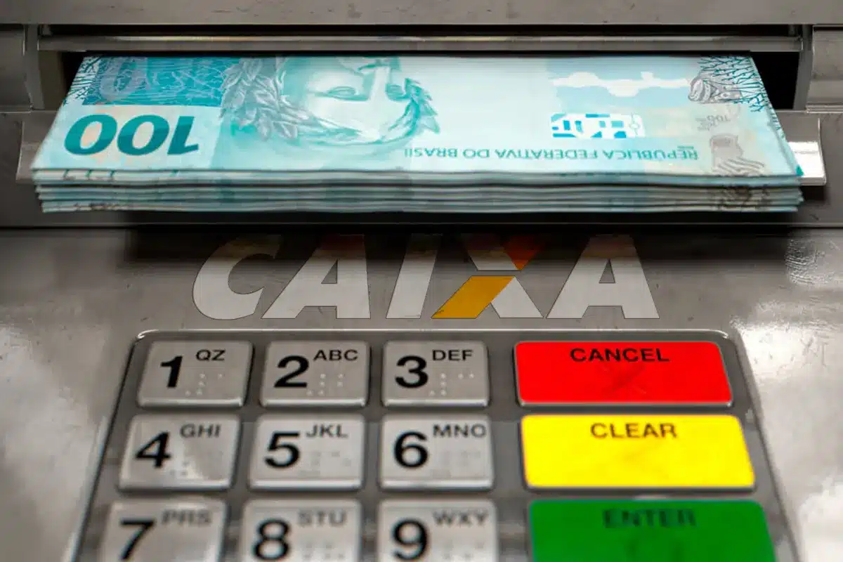 Apoio nas enchentes. Dinheiro sendo sacado em caixa eletrônico CAIXA com teclado numérico em destaque.