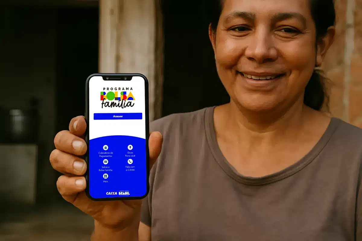 Mulher exibe aplicativo Bolsa Família em cidade beneficiada Mulher sorridente mostra celular com aplicativo do Bolsa Família na tela
