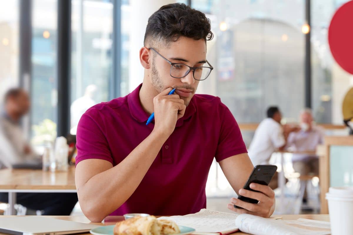 Homem olhando atento para o seu celular.