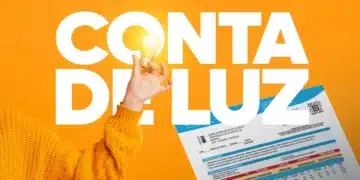 Pessoa com suéter amarelo segurando lâmpada acesa ao lado de conta de energia elétrica