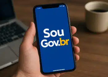 Pessoa segurando celular com o aplicativo SouGov.br aberto na tela.