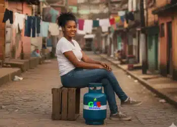 Mulher sorrindo sentada em comunidade ao lado de botijão do Gás do Povo