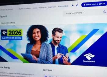 Tela de computador exibindo o portal da Receita Federal com a página do Imposto de Renda 2026, mostrando dois contribuintes usando tablet e celular, ilustrando o acesso à declaração pré-preenchida pelo portal e-CAC com conta Gov.br nível Prata ou Ouro