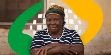 Mulher idosa de lenço estampado cruza os braços sentada, parede simples ao fundo e elementos gráficos coloridos