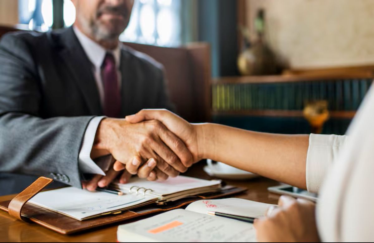 Aperto de mãos sobre documentos simbolizando direitos garantidos pela CLT em contrato de trabalho.