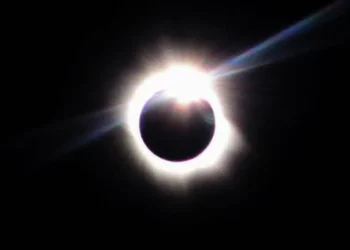 Fotografia de eclipse solar total com a coroa solar visível ao redor da Lua em fundo escuro, ilustrando o fenômeno astronômico previsto para 2 de agosto de 2027.