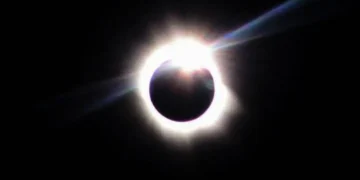 Fotografia de eclipse solar total com a coroa solar visível ao redor da Lua em fundo escuro, ilustrando o fenômeno astronômico previsto para 2 de agosto de 2027.
