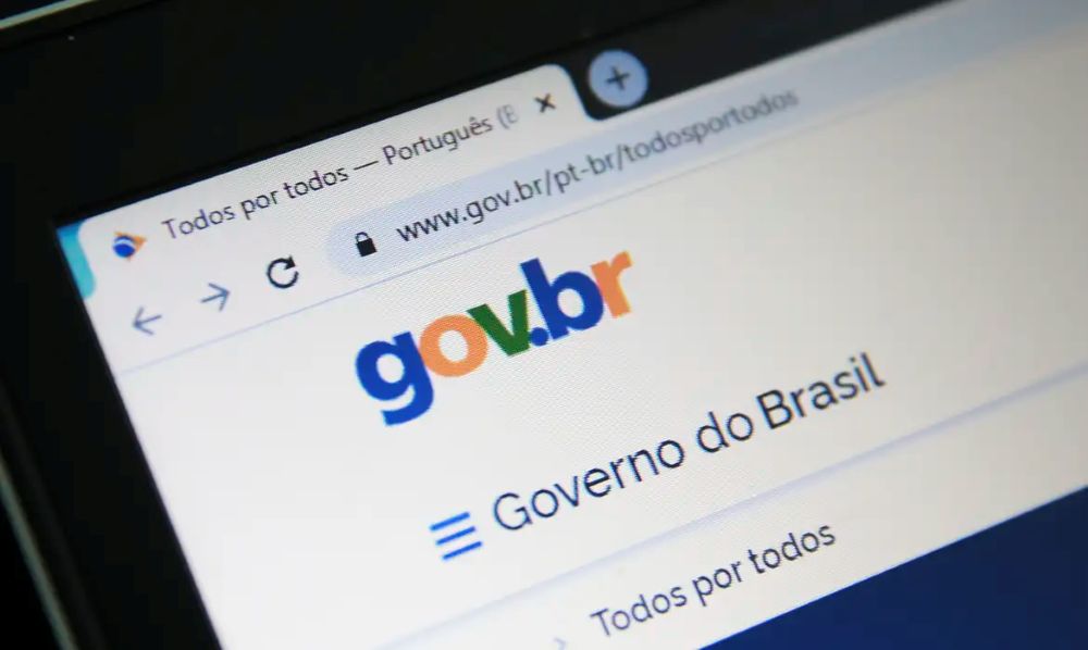 Close na tela de um notebook exibindo o site oficial gov.br aberto no navegador Chrome. O logotipo colorido 'gov.br' está centralizado, com o texto 'Governo do Brasil' logo abaixo e a barra de endereços visível no topo da página.
