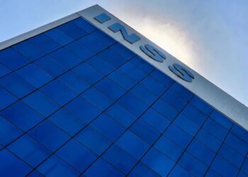 Fachada do edifício do INSS com letras em aço contra o céu azul