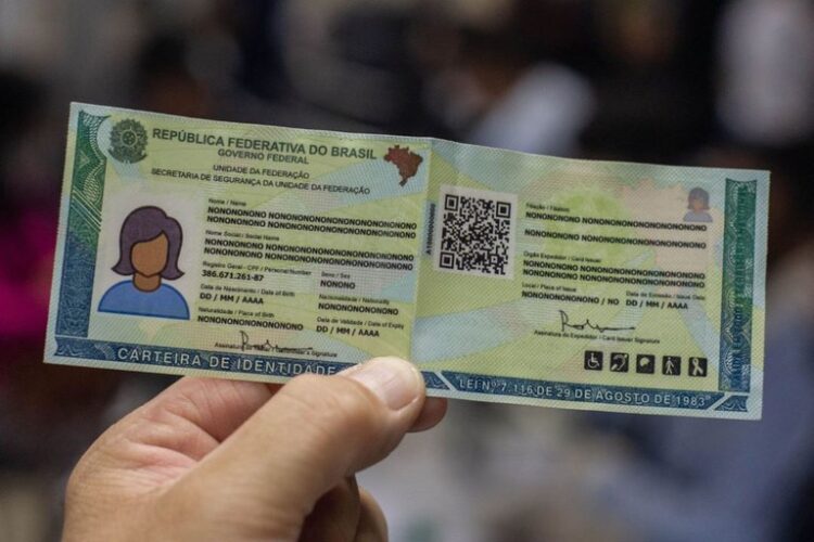 Mão segura novo modelo de RG brasileiro com fundo desfocado de atendimento