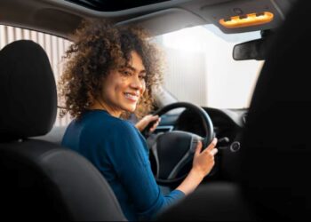 Imagem mostra uma motorista mulher dirigindo um carro, representando o novo recurso do Uber que permite que passageiras escolham viagens com motoristas mulheres na plataforma.