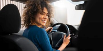 Imagem mostra uma motorista mulher dirigindo um carro, representando o novo recurso do Uber que permite que passageiras escolham viagens com motoristas mulheres na plataforma.