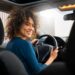 Imagem mostra uma motorista mulher dirigindo um carro, representando o novo recurso do Uber que permite que passageiras escolham viagens com motoristas mulheres na plataforma.