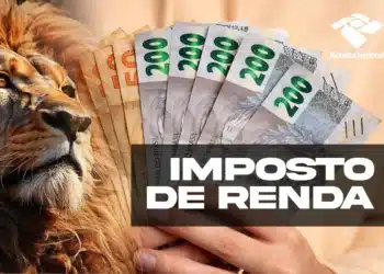 Leão próximo a mão segurando várias notas de real com destaque para cédulas de 200