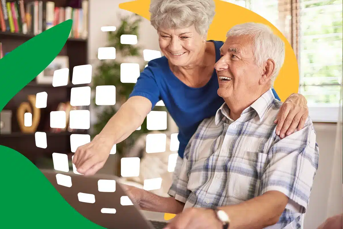 casal idosos consultando informe rendimentos inss Um casal de idosos sorridentes sentado em frente a um computador em uma sala iluminada. A mulher aponta para a tela enquanto o homem observa, ilustrando o acesso digital ao informe de rendimentos do INSS.