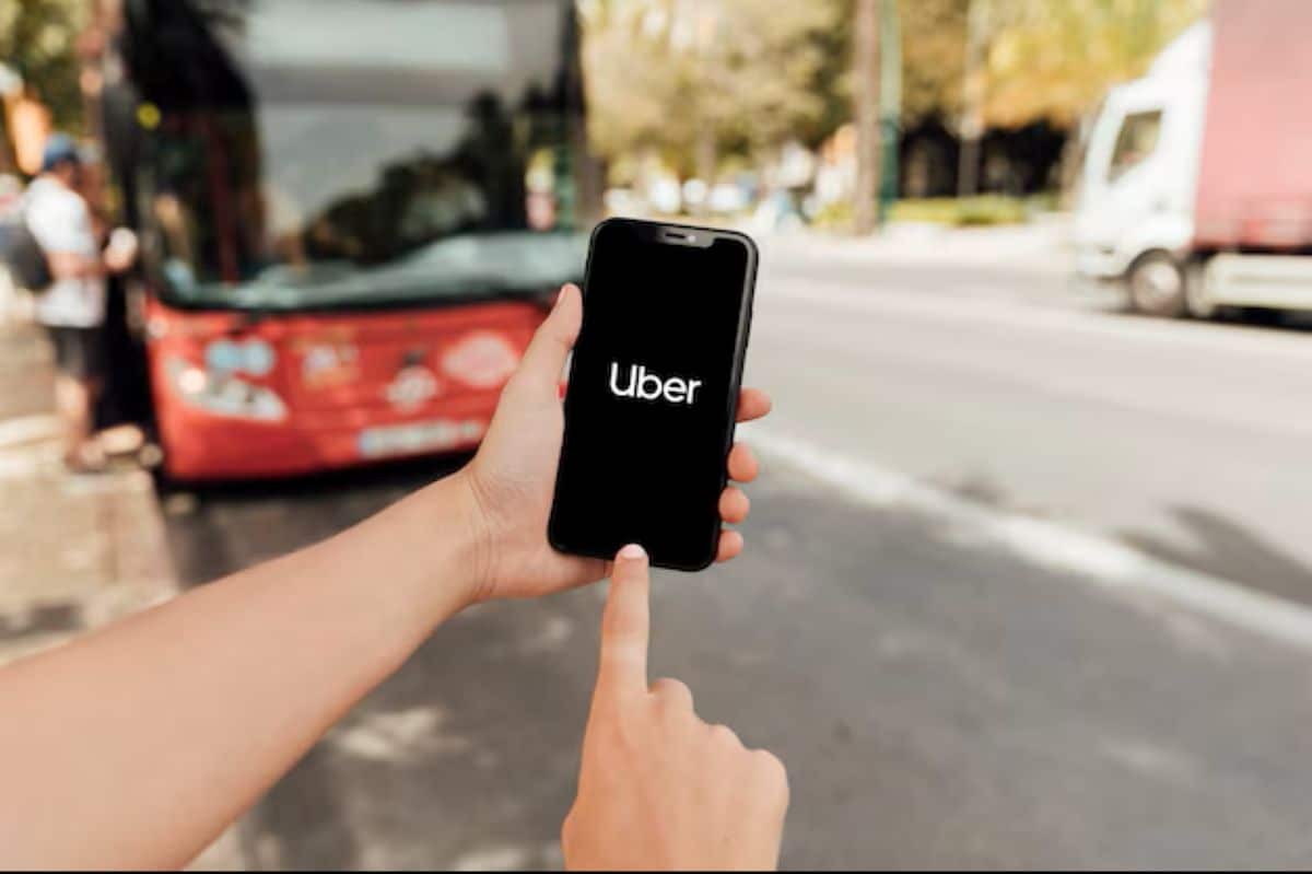 Imagem mostra um celular com o aplicativo Uber aberto na tela, representando o processo para ativar a função que permite priorizar corridas com motoristas mulheres dentro da plataforma.