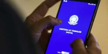 Pessoa usando celular com tela exibindo aplicativo Carteira de Trabalho Digital