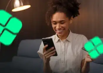 Mulher sorrindo com celular e cartão na mão rodeada de ícones do Pix — nova validação do Pix para restituição do IR 2026