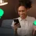 Mulher sorrindo com celular e cartão na mão rodeada de ícones do Pix — nova validação do Pix para restituição do IR 2026