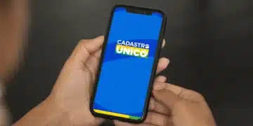 Mãos segurando celular com aplicativo do Cadastro Único na tela