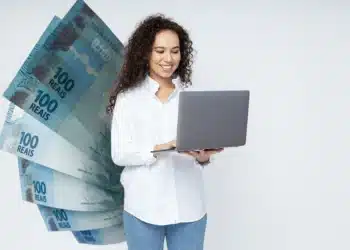 Estudante usando notebook com representação de dinheiro relacionada à bolsa do Pé-de-Meia Licenciatura.