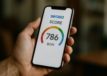 Pessoa segura celular mostrando pontuação 786 e status "bom" no app Serasa.