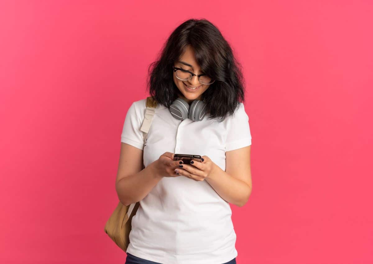 Estudante mexendo no celular.