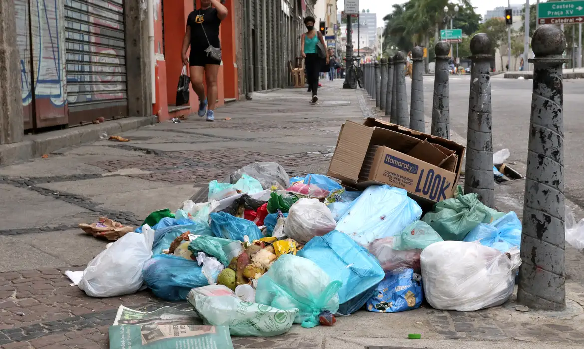 Lixo na rua. Lixo acumulado em calçada.