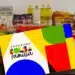 Cartão do Programa Bolsa Família colorido posicionado sobre mesa, com garrafas de óleo e alimentos embalados ao fundo.