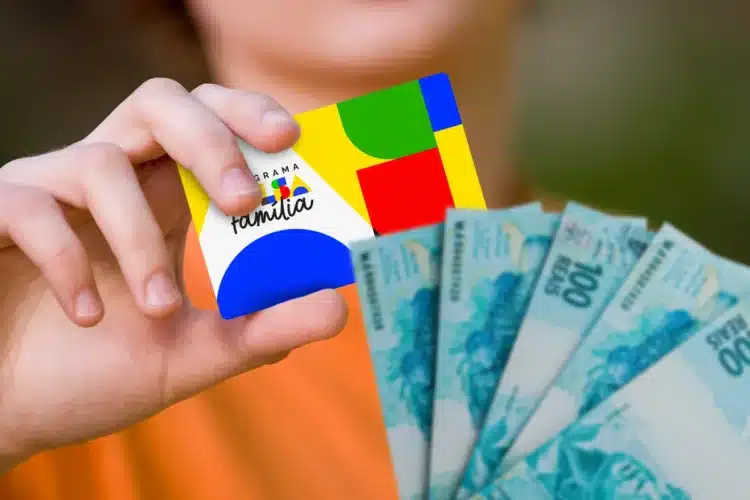 Antecipação do Bolsa Família Mão segura cartão do Programa Bolsa Família junto com notas de R$ 100 reais, representando pagamento do Bolsa Família.