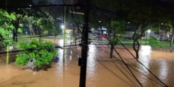 Rua alagada após chuvas intensas, mostrando áreas afetadas pela enchente.