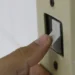 Mão aciona interruptor de luz, representando o acesso ao desconto na tarifa de energia elétrica pelo programa "Luz do Povo" em 2026