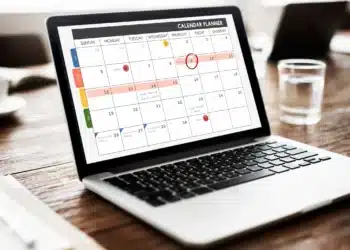 Calendário planejador aberto em notebook mostrando datas marcadas para organização dos feriados nacionais de 2026