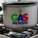 Panela de alumínio com alças pretas sobre boca de fogão acesa, exibindo logomarca "Gás do Povo" em cores verde, azul e vermelho