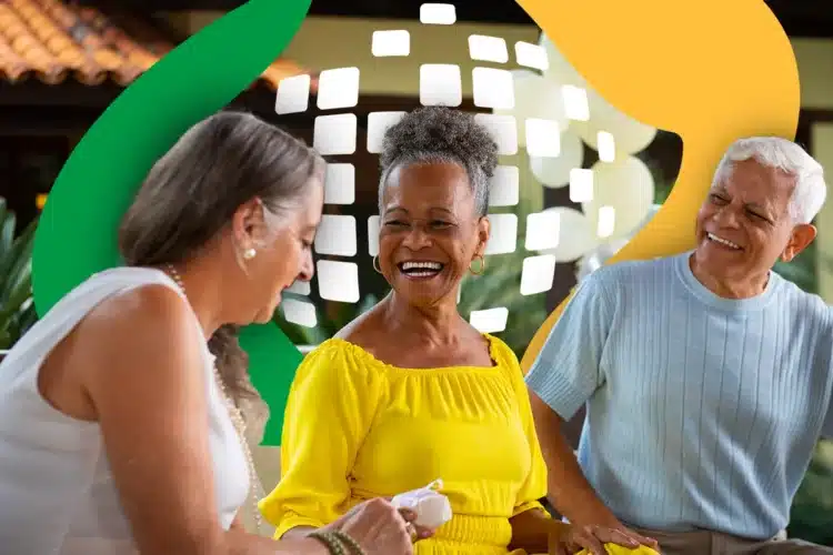 Pericia medica do INSS 2026 Três idosos sorridentes conversam em ambiente externo: mulheres com blusas branca e amarela e homem de blusa azul claro.