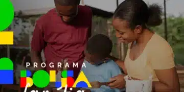 Casal negro e criança em oficina, com logo do Programa Bolsa Família em verde, amarelo, azul e vermelho.