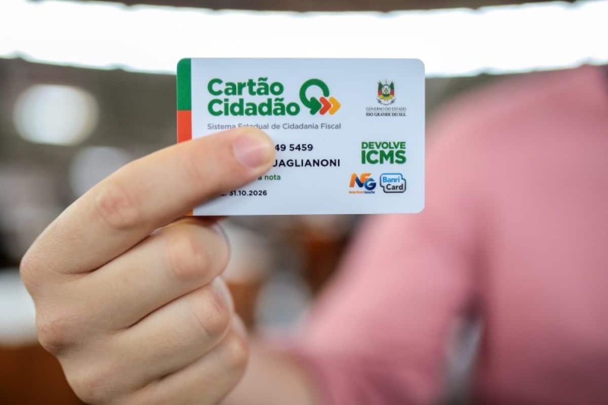 Pessoa segurando Cartão Cidadão do programa Devolve ICMS