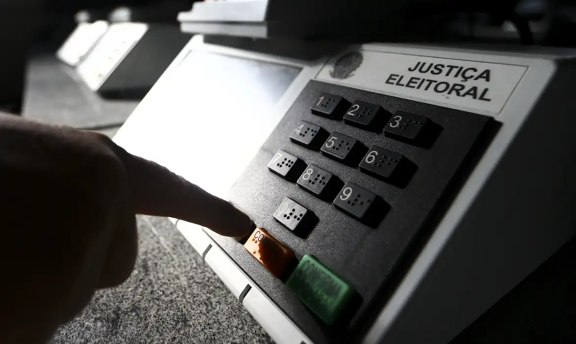 Prazo final para regularização do título de eleitor é 6 de maio Eleitor digita código em urna eletrônica da Justiça Eleitoral, em referência ao prazo final de regularização do título de eleitor em 6 de maio de 2026.