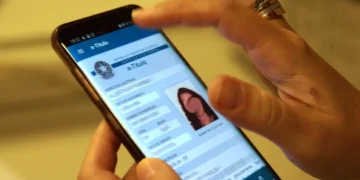 Pessoa consulta o aplicativo e-Título no celular, para verificar a situação eleitoral e realizar a regularização do título pelo portal do TSE.