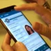 Pessoa consulta o aplicativo e-Título no celular, para verificar a situação eleitoral e realizar a regularização do título pelo portal do TSE.