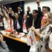Parlamentares de mãos dadas levantadas celebram aprovação da PEC contra escala 6x1, com camisetas e cartazes da campanha