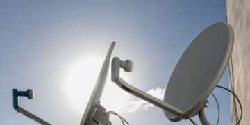 Antenas parabólicas instaladas em telhado com céu azul ao fundo