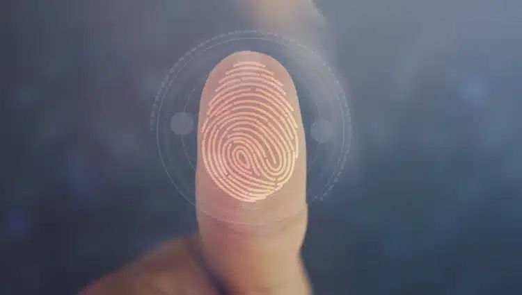Biometria obrigatória 2026 Dedo com impressão digital iluminada passando por scanner biométrico circular com código binário ao redor.