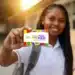 Pé-de-Meia maio calendário: estudante do ensino médio público segura cartão oficial do programa, com a inscrição "A poupança do ensino médio", em referência aos pagamentos liberados pelo MEC ao longo do mês