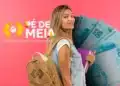 Estudante com mochila e cadernos ao lado da logo do Pé-de-Meia e notas de R$ 100