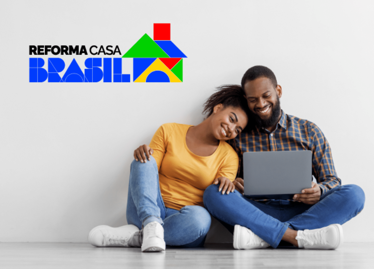 Casal utilizando notebook ao lado do logo do Reforma Casa Brasil