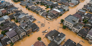 Vista aérea de enchente em bairro residencial e ruas alagadas.