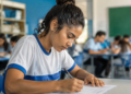 Jovem estudante preenchendo inscrição para curso de qualificação profissional do Pronatec em ambiente escolar.